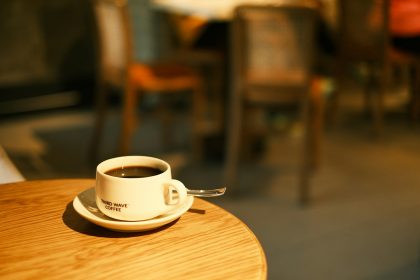 a cup of coffee sitting on top of a wooden table